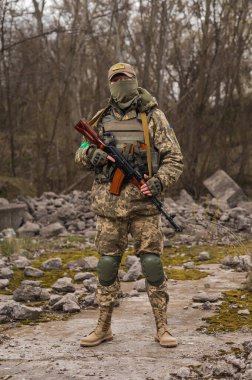 Soldier of the Armed Forces of Ukraine. Military man in tactical uniform with a machine gun in his hands