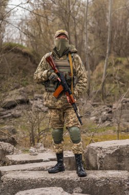 Soldier of the Armed Forces of Ukraine. Military man in tactical uniform with a machine gun in his hands