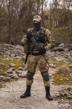 Soldier of the Armed Forces of Ukraine. Military man in tactical uniform with a machine gun in his hands