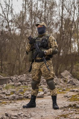 Soldier of the Armed Forces of Ukraine. Military man in tactical uniform with a machine gun in his hands