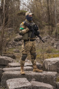 Soldier of the Armed Forces of Ukraine. Military man in tactical uniform with a machine gun in his hands
