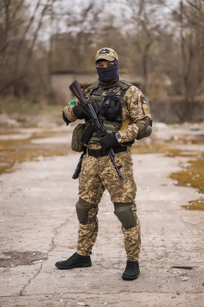 Soldier of the Armed Forces of Ukraine. Military man in tactical uniform with a machine gun in his hands