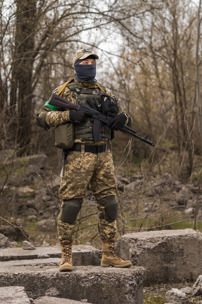 Soldier of the Armed Forces of Ukraine. Military man in tactical uniform with a machine gun in his hands