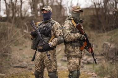 Üniformalı iki Ukraynalı asker Kalaşnikof saldırı tüfeğini hedefliyor