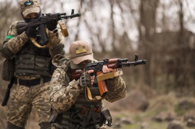 Üniformalı iki Ukraynalı asker Kalaşnikof saldırı tüfeğini hedefliyor