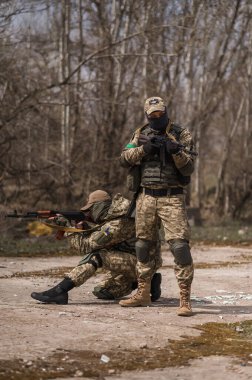 Üniformalı iki Ukraynalı asker Kalaşnikof saldırı tüfeğini hedefliyor