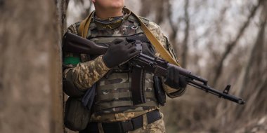 Büyük beton bir duvarın yanında üniformalı Ukraynalı asker.