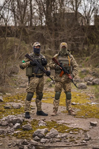 Üniformalı iki Ukraynalı asker Kalaşnikof saldırı tüfeğini hedefliyor