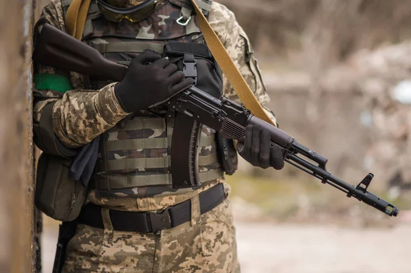 Ukrainian soldier in uniform near a large concrete wall