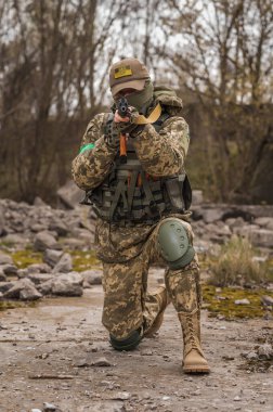 Ukrainian soldier of the Armed Forces of Ukraine sits taking aim