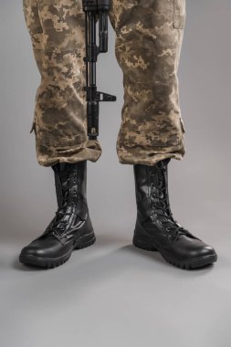 Gri bir geçmişi olan Ukraynalı bir askerin üzerinde deri askeri botlar.