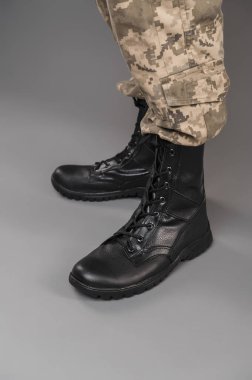 Gri bir geçmişi olan Ukraynalı bir askerin üzerinde deri askeri botlar.