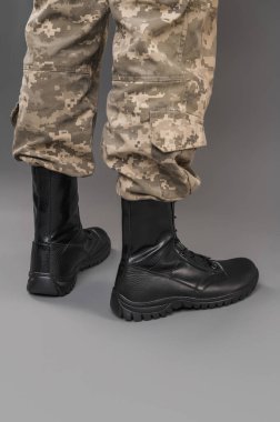 Gri bir geçmişi olan Ukraynalı bir askerin üzerinde deri askeri botlar.