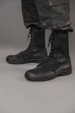Gri bir geçmişi olan Ukraynalı bir askerin üzerinde deri askeri botlar.