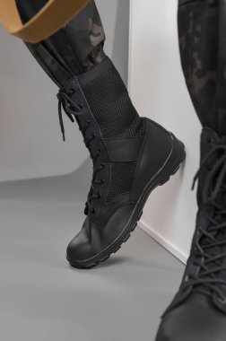 Gri bir geçmişi olan Ukraynalı bir askerin üzerinde deri askeri botlar.