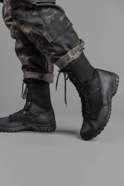 Gri bir geçmişi olan Ukraynalı bir askerin üzerinde deri askeri botlar.