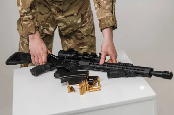 Bir Asker Masadan Makineli Tüfek Alır Beyaz Bir Masada Fişekli — Stok fotoğraf