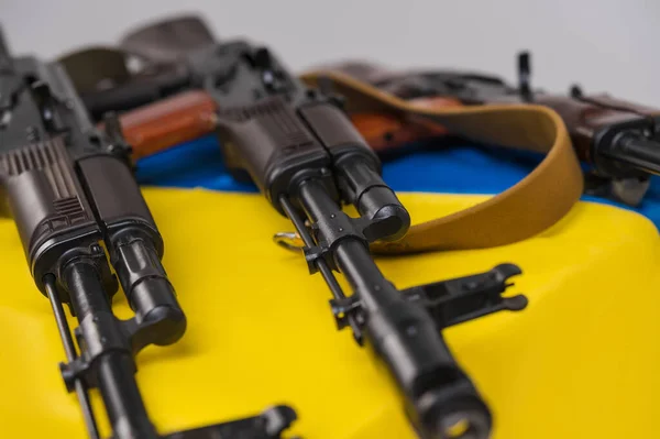 3支卡拉什尼科夫74突击步枪装在乌克兰蓝色和黄色国旗上 — 图库照片