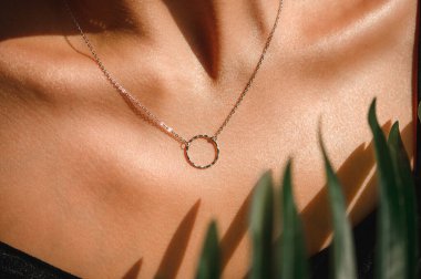 Güzel bir kızın göğsünde yüzük olan bir zincir.