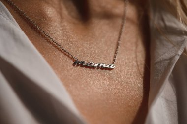 Gümüş bir kolye, genç bir kızın göğsündeki gümüş bir kolye şeklinde.