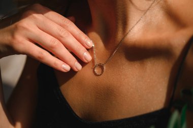 Genç bir kızın göğsünde zincir şeklinde altın bir kolye.