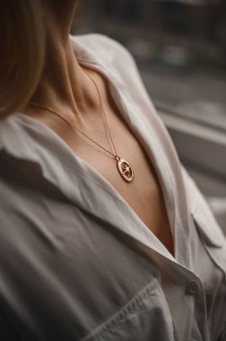 Genç bir kızın boynunda zincirlenmiş bir yıldızla altın bir kolye.