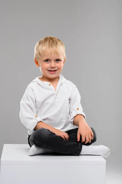 Small Fair Haired Boy Shirt Pants Sits White Cube Portrait — Stock Photo, Image
