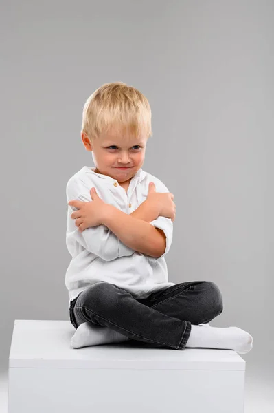 Piccolo Ragazzo Dai Capelli Biondi Camicia Pantaloni Siede Cubo Bianco — Foto Stock