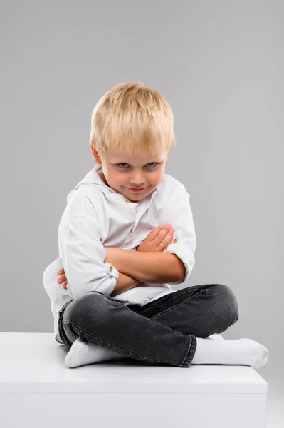 Piccolo Ragazzo Dai Capelli Biondi Camicia Pantaloni Siede Cubo Bianco — Foto Stock