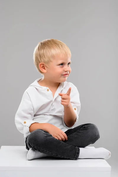 Piccolo Ragazzo Dai Capelli Biondi Camicia Pantaloni Siede Cubo Bianco — Foto Stock