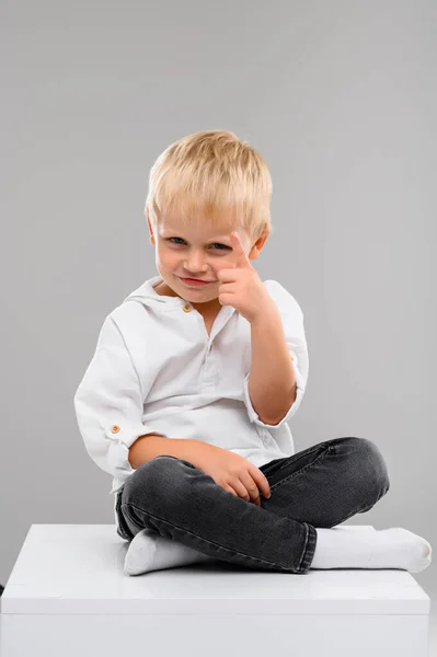 Piccolo Ragazzo Dai Capelli Biondi Camicia Pantaloni Siede Cubo Bianco — Foto Stock