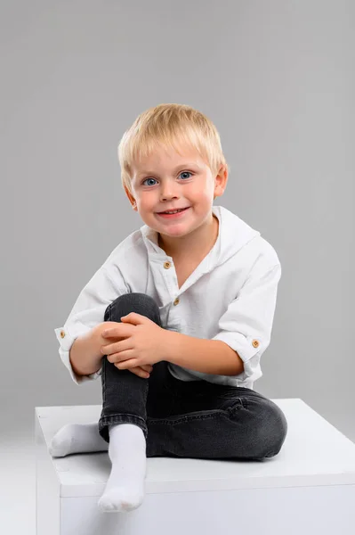 Piccolo Ragazzo Dai Capelli Biondi Camicia Pantaloni Siede Cubo Bianco — Foto Stock