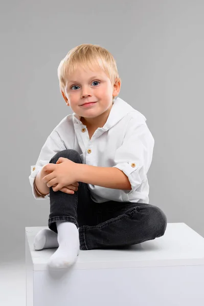 Malý Světlovlasý Chlapec Košili Kalhotách Sedí Bílé Kostce Portrét Spektrum — Stock fotografie