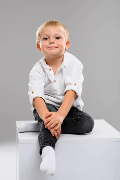 Malý Světlovlasý Chlapec Košili Kalhotách Sedí Bílé Kostce Portrét Spektrum — Stock fotografie