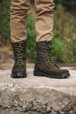 Military man in dark green leather tactical boots