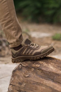 Bej derili taktik spor ayakkabılı asker.