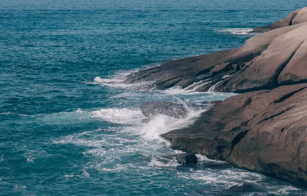 De golven van de Atlantische Oceaan storten neer op rotsen met spatten in Tenerife — Stockfoto