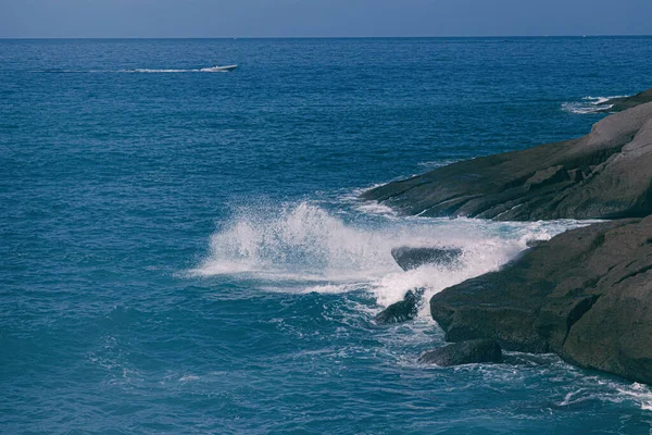The waves of the Atlantic Ocean crash on rocks with splashes in Tenerife
