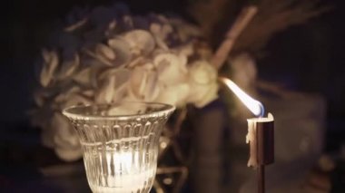 Parafin Mumları, iki laleli bir masada beyaz alevlerle yanar. Odadaki bir masanın üzerindeki mum. Hafıza konsepti, ritüel, kutlama. Kilise ayinleri. 4 bin. Kapat..