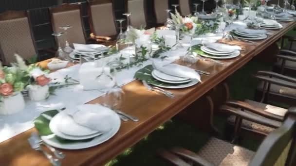 Decoración festiva de mesa en colores blanco y verde con flores frescas y hierba — Vídeo de stock