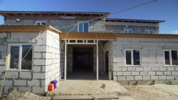 Un bâtiment en brique en construction, sur fond de ciel bleu. Construction et construction d'une nouvelle maison. Maison en construction — Video