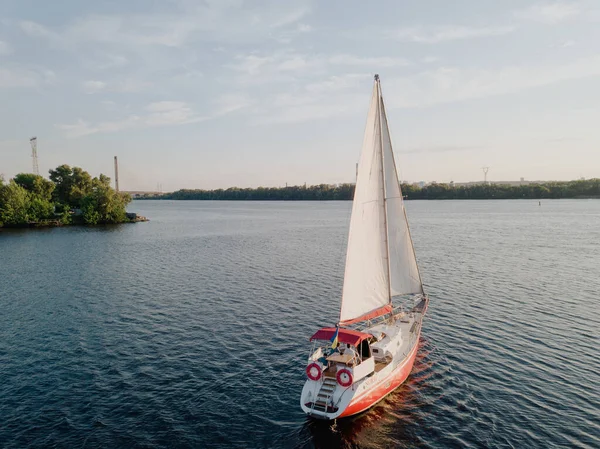 Bateau rouge avec voiles ouvertes dans la rivière avec un beau paysage — Photo