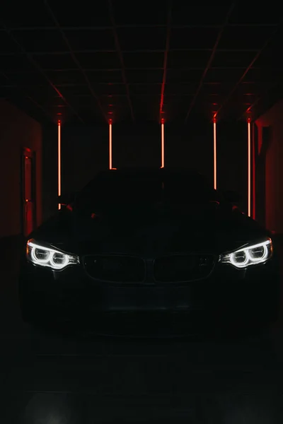 Los faros del coche se queman en la oscuridad. Por la noche el coche quema las luces —  Fotos de Stock