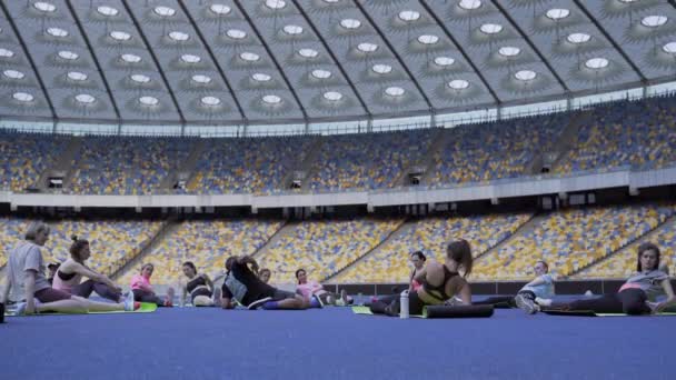 Smala atletiska unga flickor med tränarträning på arenan — Stockvideo