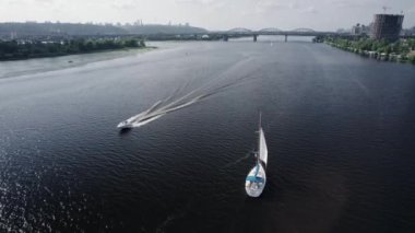 Bir şehrin arka planında nehirde kayıklara binmek. Hava görünümü