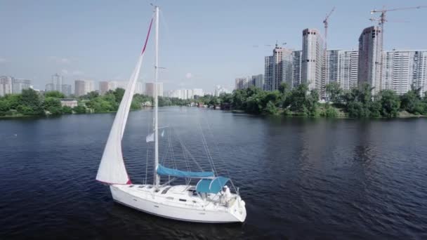 Kyiv şehrinin arka planında beyaz bir yelkenli yatının havadan görünüşü — Stok video