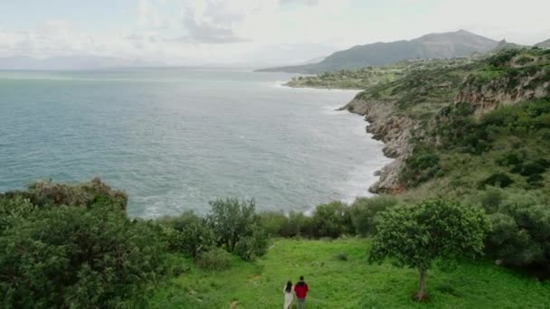 夫婦はシチリア島の山と海の景色を見ています。空中ビデオ — ストック動画
