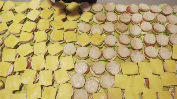 Zbliżenie kucharzy wkładających ser na bułeczki. Przygotowuję dużo kanapek. — Wideo stockowe