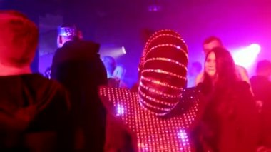 Kulüpte elmas kasklı bir kadın dans ediyor.