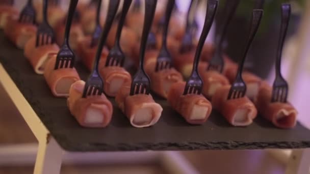 Primer plano de canapés decorados con un tenedor negro — Vídeo de stock